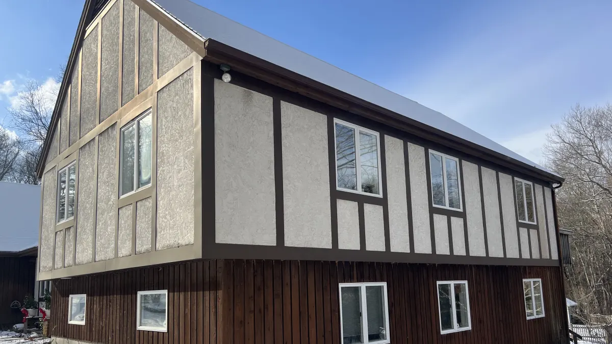 Before - weathered stucco panels and stained board-and-batten on the gable end of a Southbury, CT home